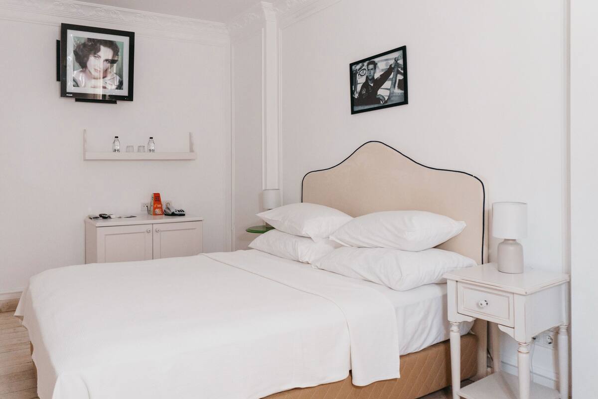 Une chambre à coucher au style minimaliste, avec un lit, des tables de chevet et une petite table de nuit.