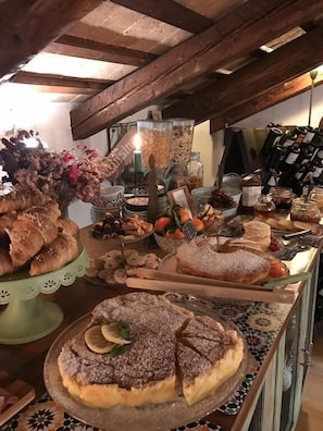 Mostrador de una panadería con diversas opciones de repostería, incluyendo pasteles y tartas, bajo un techo de madera.