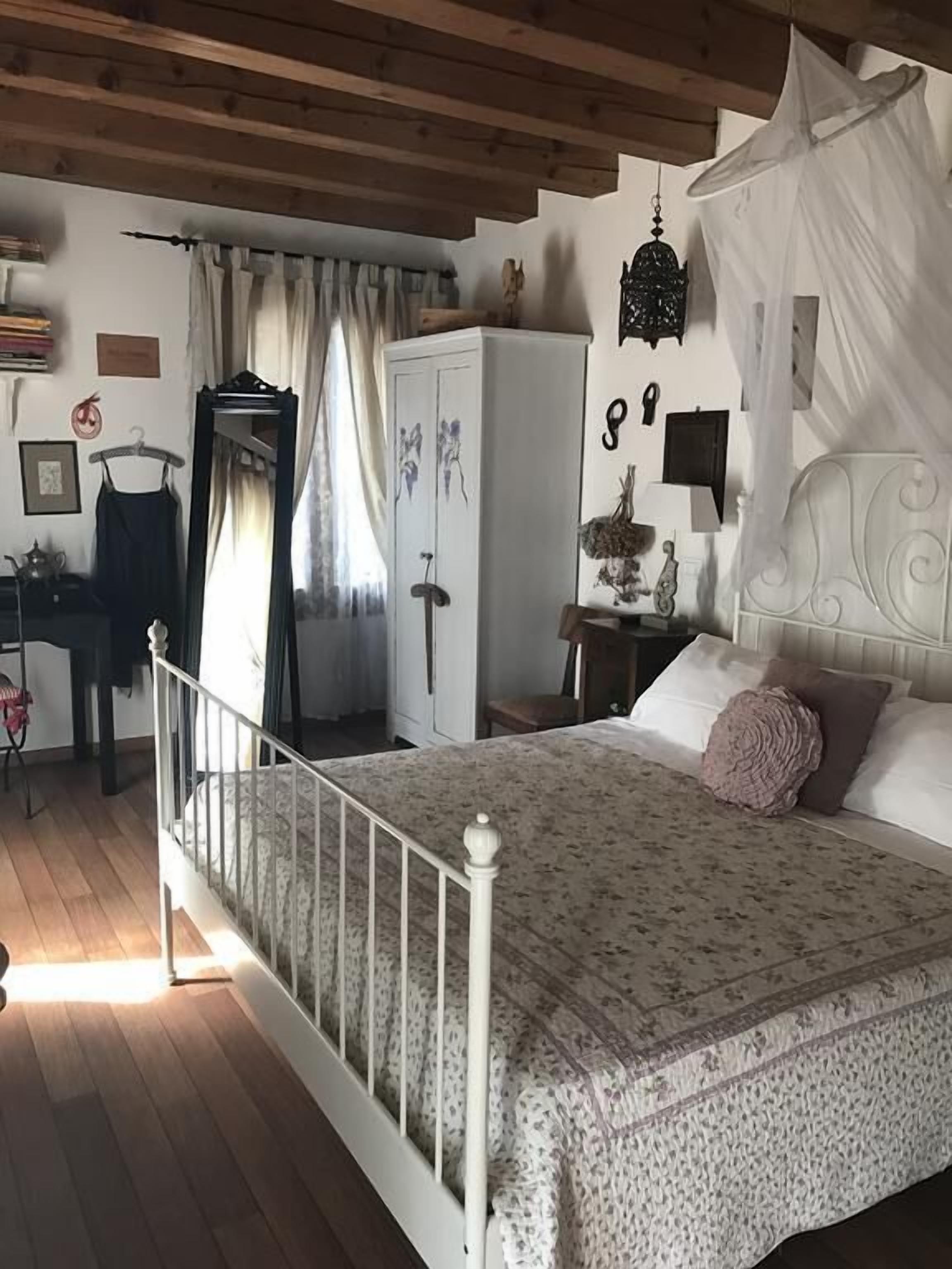 A bedroom with a bed, a wardrobe, a desk, and a hanging chair.