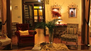 A cozy lobby with a red armchair, a wooden coffee table, and a bookshelf with books. - Morenica del Rosario (Cuenca)