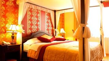 Una habitación de hotel con cama, mesitas de noche, lámparas y cortinas.