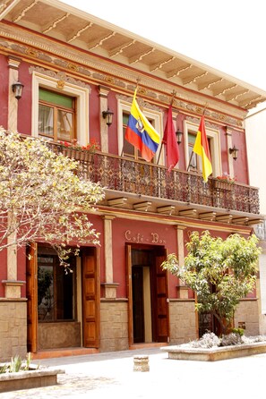 A building with a balcony, a sign reading "Café Bar", and flags. - Morenica del Rosario (Cuenca)