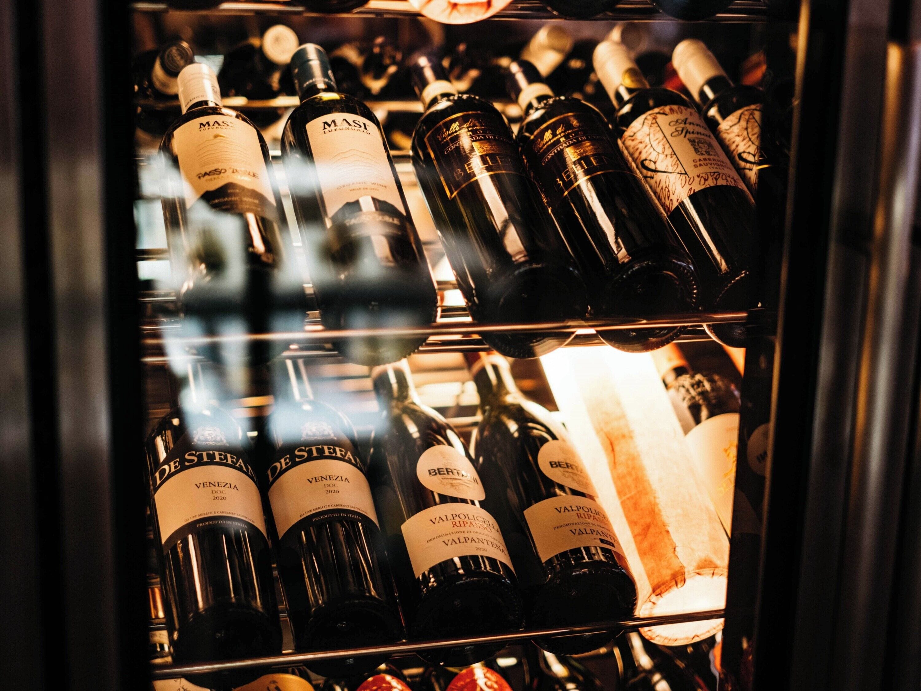 A wine rack with bottles labeled 'Venezia DOC 2020' and 'Valpolicella Ripasso'.