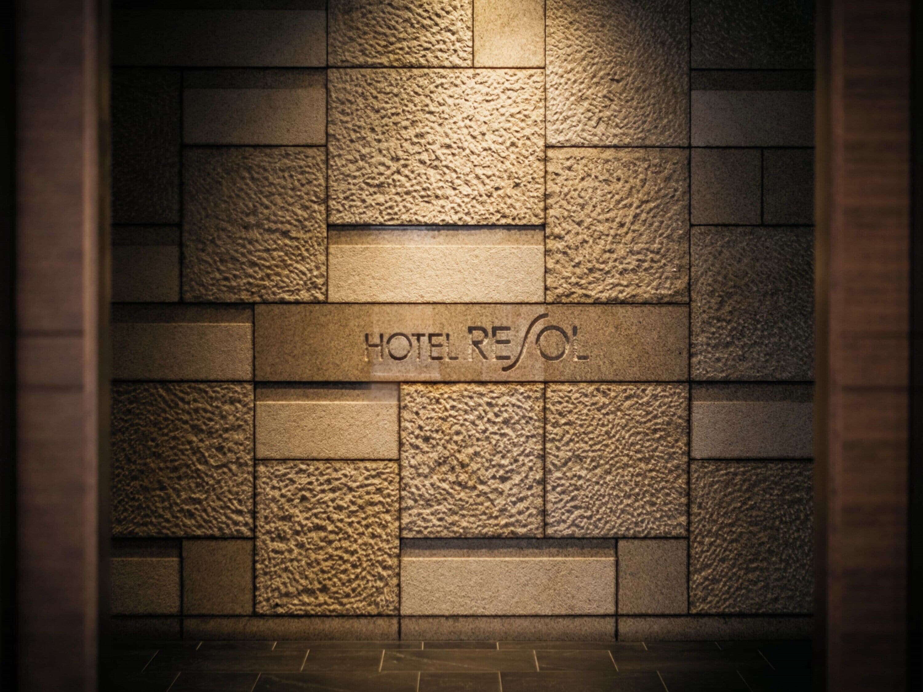 Una pared con el texto 'HOTEL RESOL' grabado en un material que imita la piedra.
