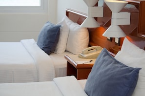 A hotel room with two beds, a bedside table with a telephone, and a lamp. - Hotel Hostal de Cortés (Veracruz)