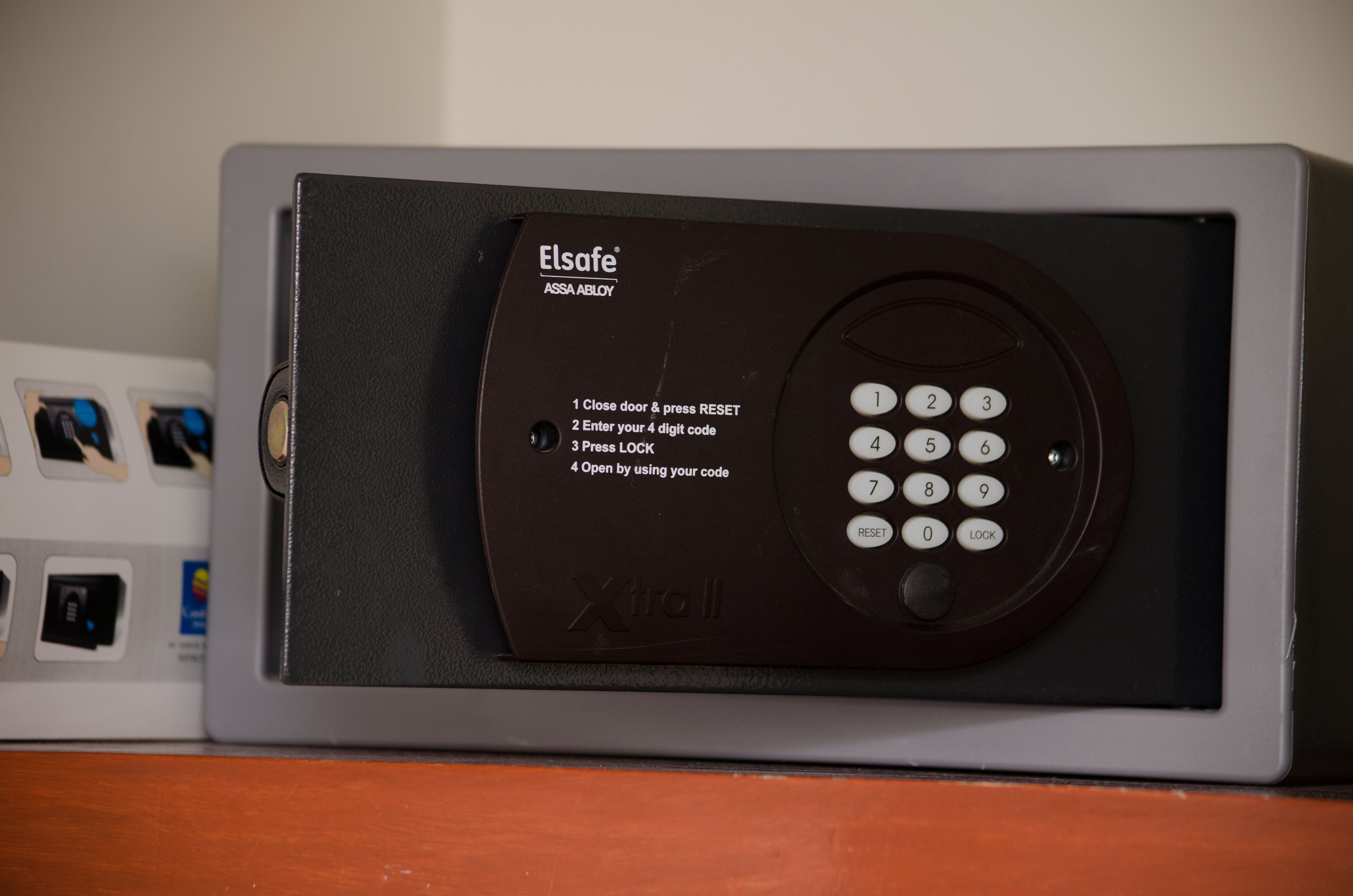 A black and gray electronic device with a keypad and instructions for use.