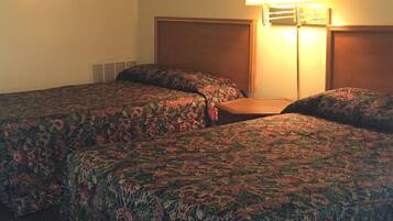 A hotel room with two beds, a nightstand, a lamp, and a painting on the wall.