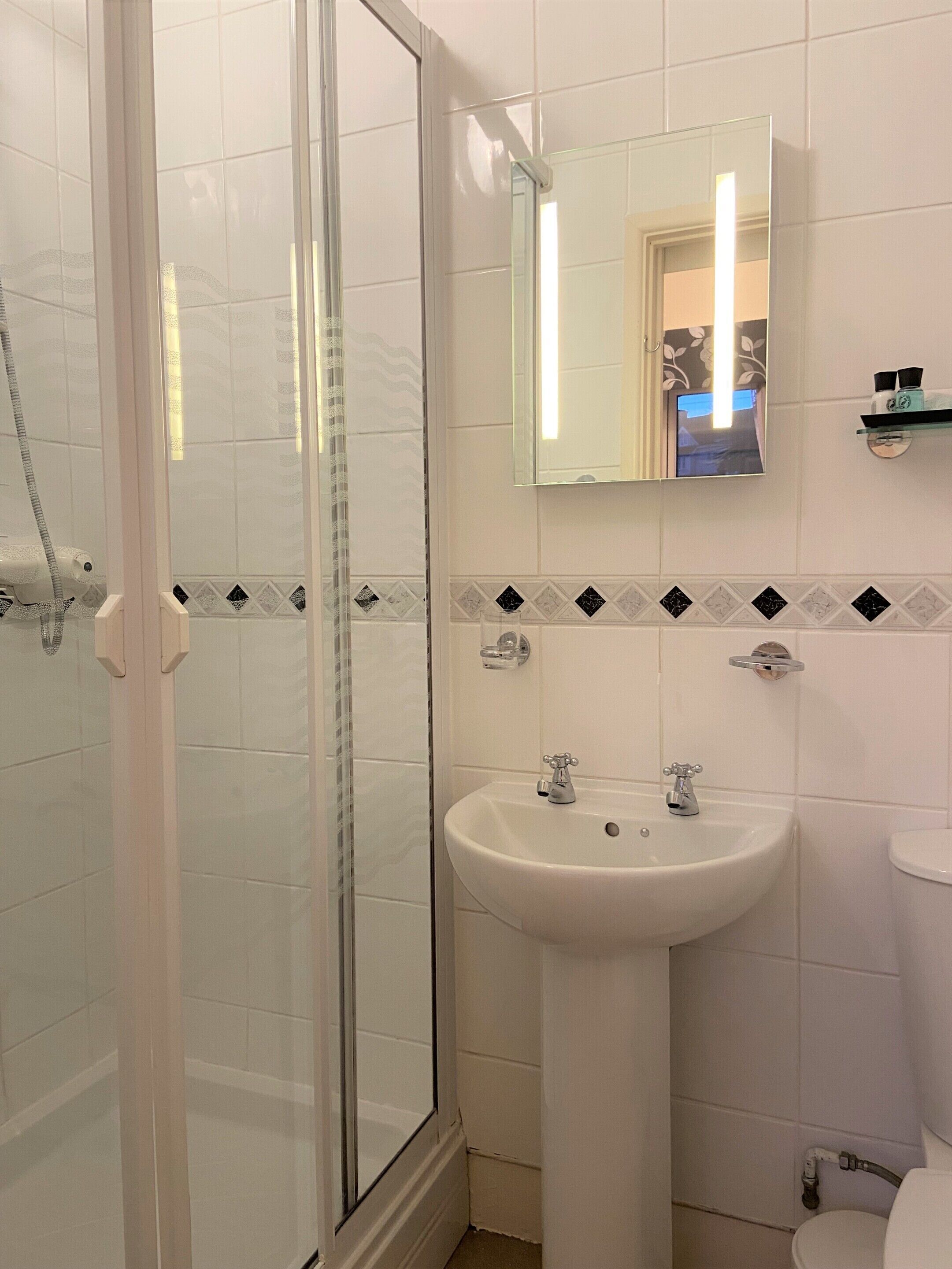 Ein Badezimmer mit Duschkabine, Waschbecken und Toilette.