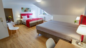 Un dormitorio moderno con una cama grande, un escritorio y una silla. Se ve una ventana con vistas al exterior.