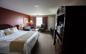 Une chambre d’hôtel avec un grand lit, un bureau équipé d’un ordinateur, une chaise et un téléviseur.