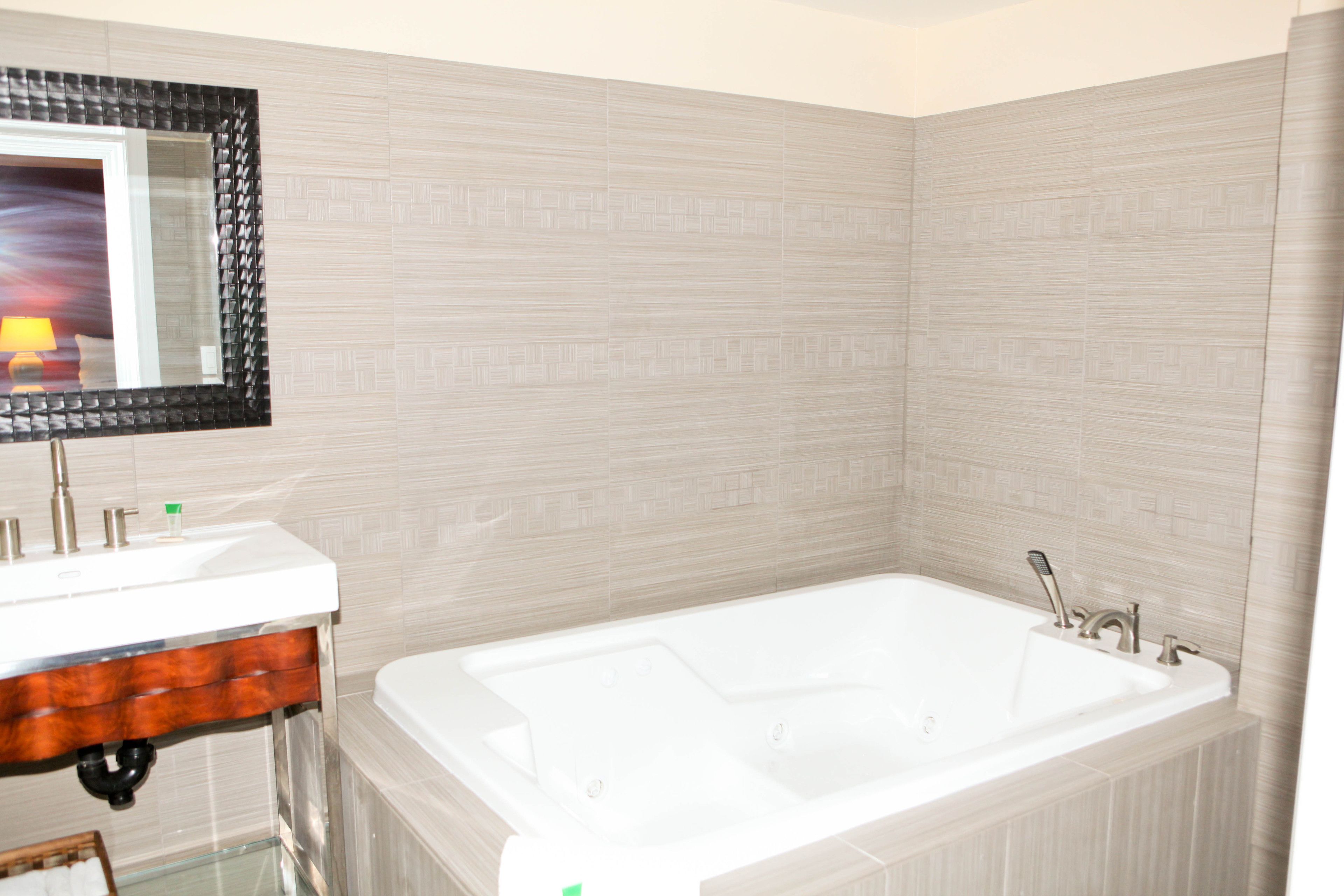 A bathroom with a white sink, a mirror, and a bathtub.