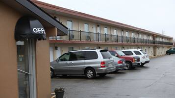 A motel with a row of parked cars and a visible office entrance.