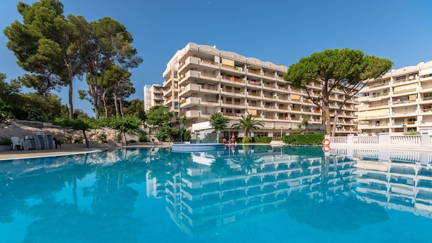 A hotel with a swimming pool, surrounded by trees and a clear sky. - Catalonia Gardens (Salou)