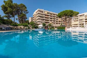 A hotel with a swimming pool, surrounded by trees and a clear sky. - Catalonia Gardens (Salou)