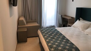A hotel room with a bed, a desk, a chair, and a TV mounted on the wall. - Hôtel Restaurant Le Filosorma (Galeria)