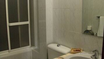 A bathroom with a toilet, sink, and shower area.