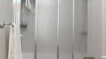 Une salle de bain avec une douche à parois de verre, des toilettes et un porte-serviettes avec des serviettes.