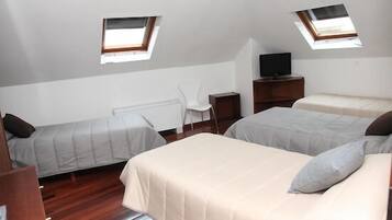 Habitación cuádruple | Caja fuerte, escritorio, cortinas opacas y cunas gratuitas