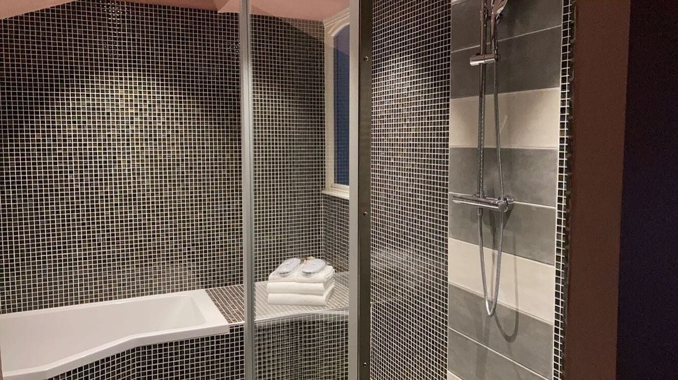 Een badkamer met een douche, een bad en een toilet.