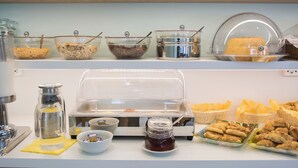 A buffet setup with various food items and condiments. - Tholos (Delphi)