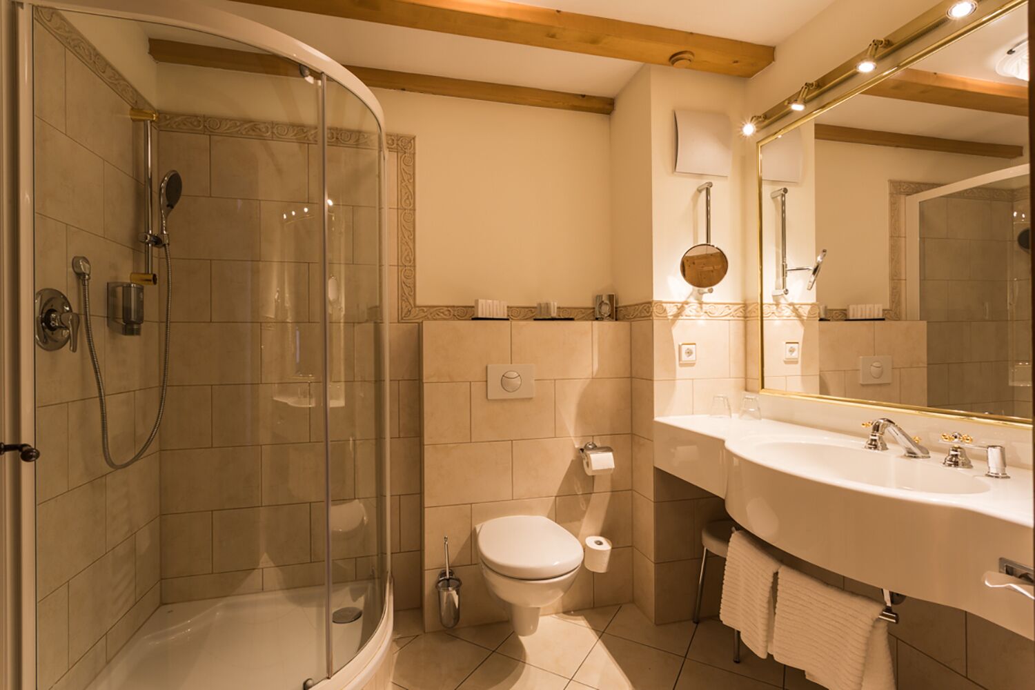 Ein Badezimmer mit einer Duschkabine, einer Toilette und einem Waschbecken mit Spiegel.