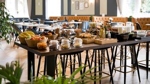 Un bufé de desayuno con diversas frutas, cereales y bebidas.