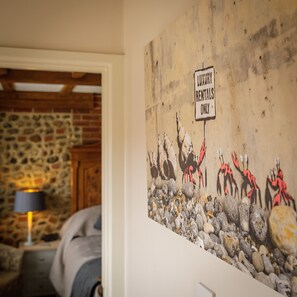 A wall with a 'Luxury Rentals Only' sign and a mural of crabs. - The Barns at Thorpe Market (Norwich)