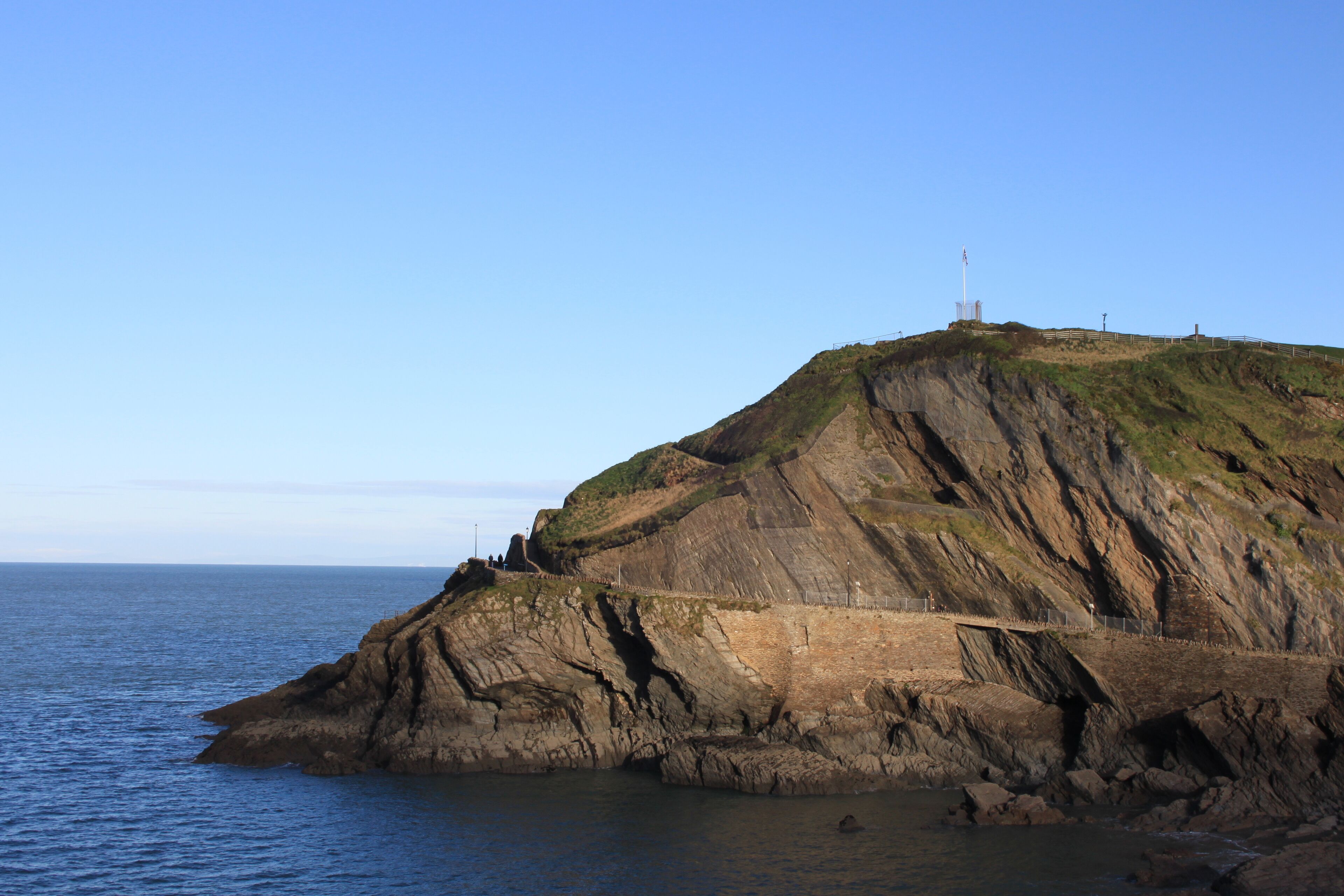 Une falaise côtière surmontée d’un phare et dotée d’une plateforme d’observation.