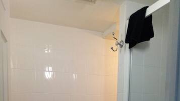 A bathroom with a toilet, a shower, and a towel rack.
