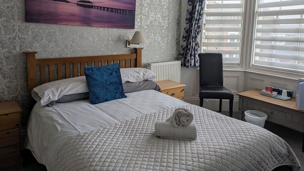 A neatly arranged bedroom with a bed, a desk, and a chair. - The Kenton (Scarborough)