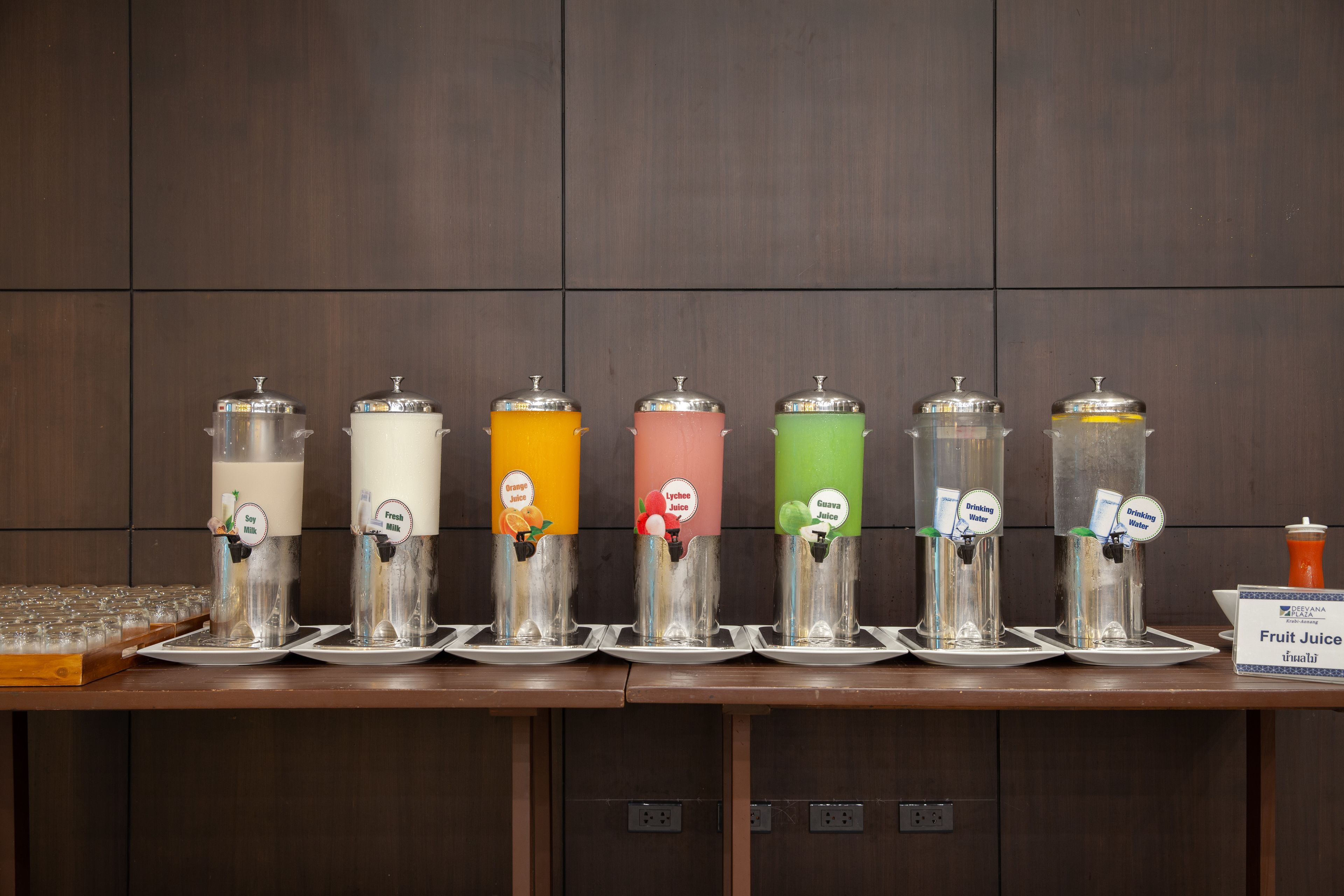 A juice dispenser station with multiple options including soy milk, fresh juice, orange juice, lychee juice, and green juice.