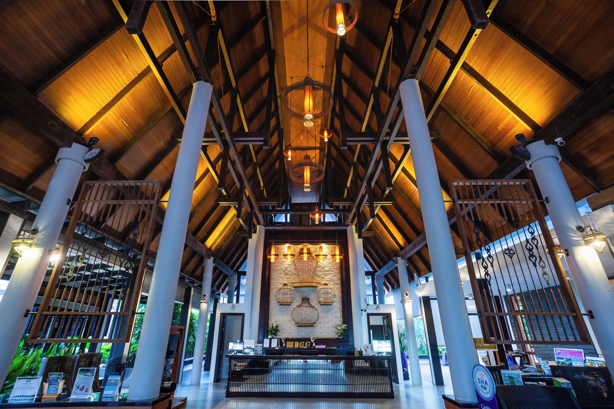 A spacious lobby with high ceilings, wooden beams, and a central decorative wall.