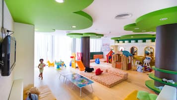 Children can play and relax in this vibrant play area with a slide, climbing wall, and playhouse.