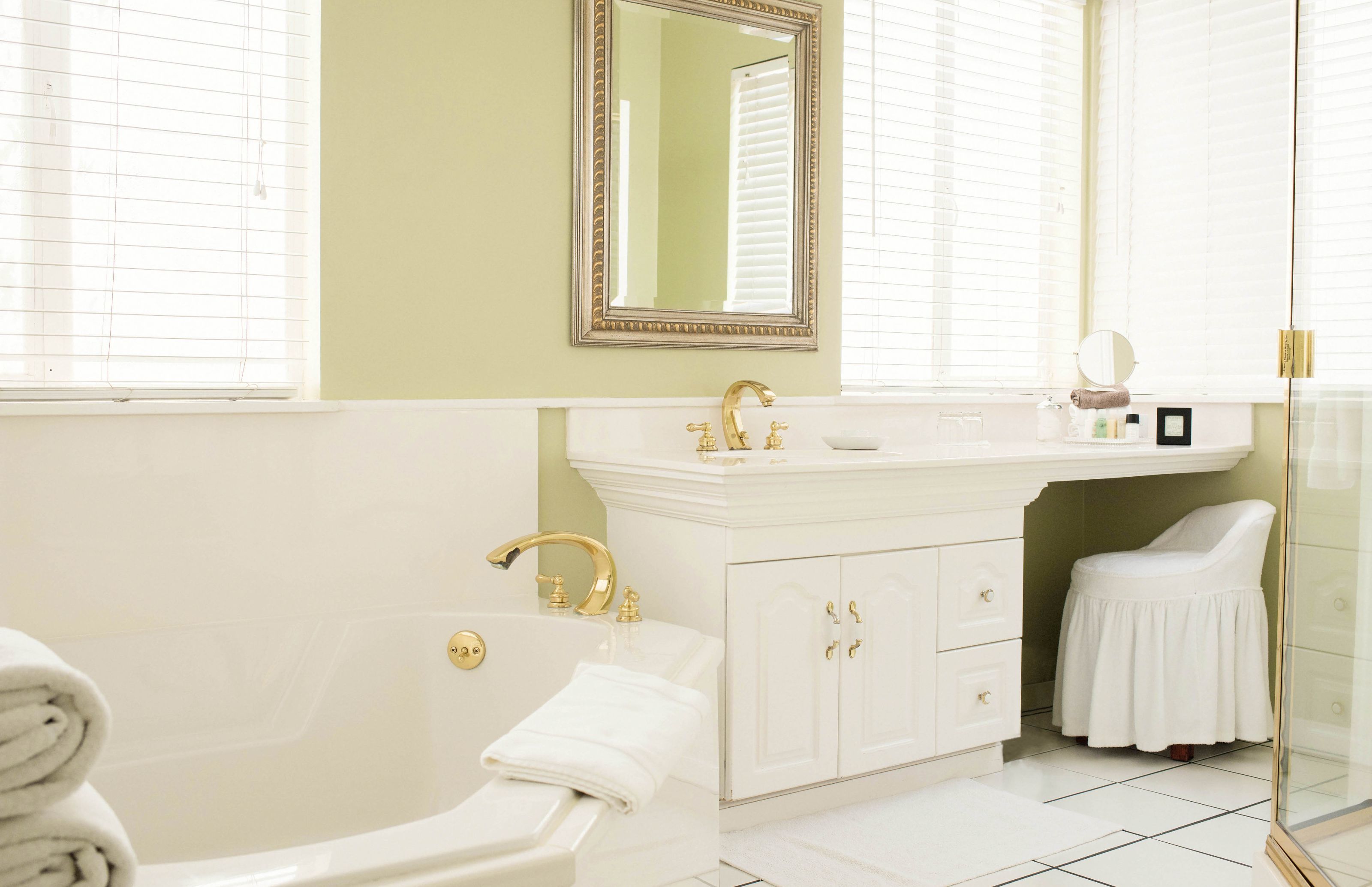 A bathroom with a bathtub, a vanity with a mirror, and a toilet.
