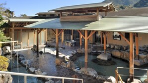 A traditional Japanese onsen with wooden structures and a stone pathway. - Hotel Okada (Hakone)