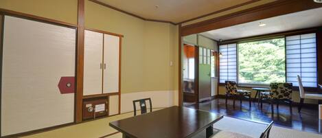 A traditional Japanese-style room with tatami flooring, a low table, and sliding doors.