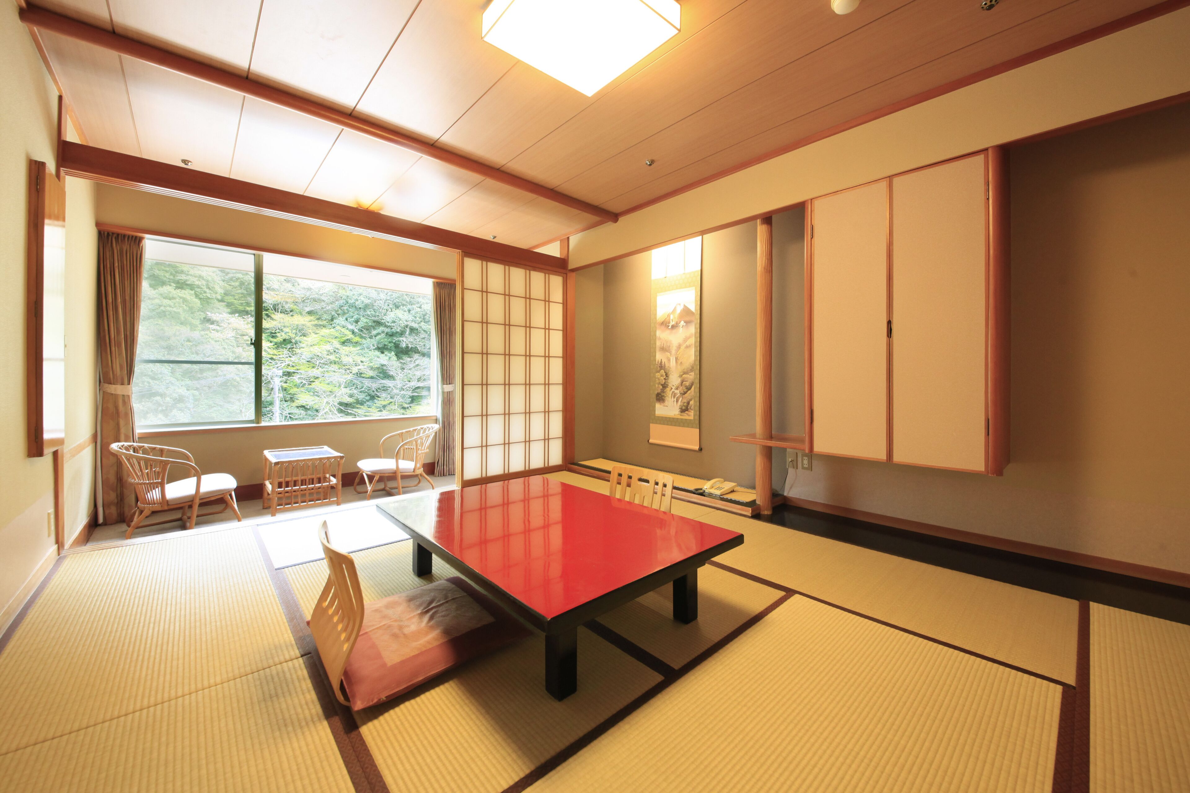 A traditional Japanese room with tatami flooring, a low table, and sliding doors.