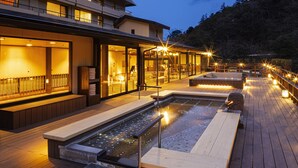 A wooden deck with a hot tub and seating area, overlooking a forested hillside. - Hotel Okada (Hakone)
