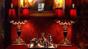 A room with a portrait framed in gold, red curtains, and a table with ornate candle holders. - Alexander Mansion Bed and Breakfast (Winona)