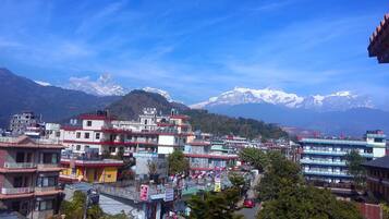 A town with colorful buildings and a backdrop of snow-capped mountains.