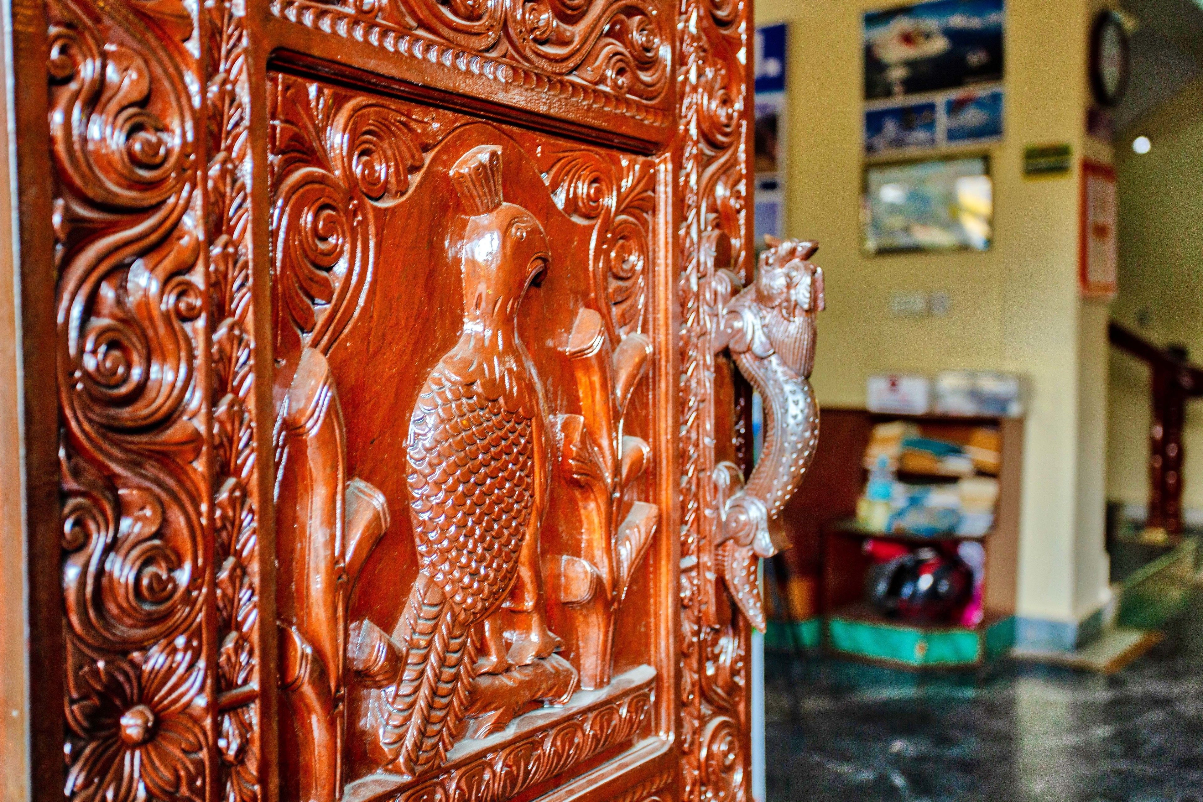 Una puerta de madera con elaboradas tallas de un pez y un dragón.
