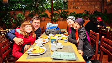 Enjoy a casual meal with friends or family in this serene outdoor dining area surrounded by lush greenery.