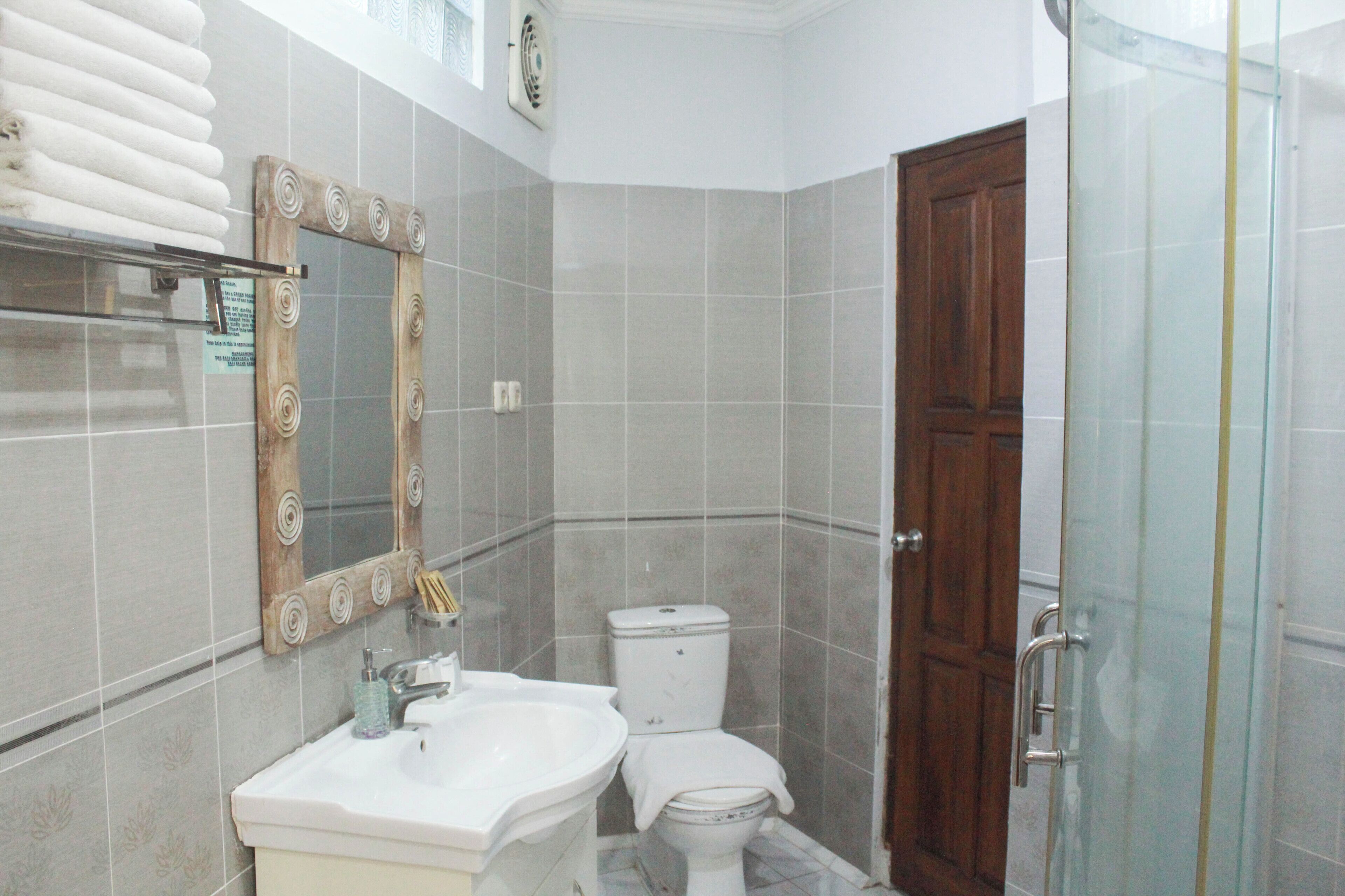 A bathroom with a sink, mirror, toilet, and shower.