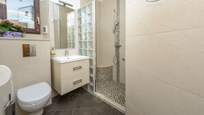 Un baño moderno con inodoro, lavabo y ducha.