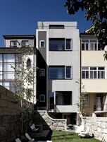 A modern multi-story building with a mix of architectural styles, including a stone facade and a metal exterior.