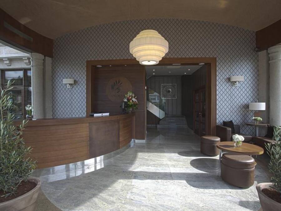 A lobby with a reception desk, seating area, and a staircase leading to another floor.