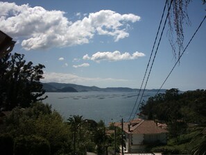 A coastal view with a clear sky, a body of water, and distant mountains. - Casa Rural A Rega (Poio)