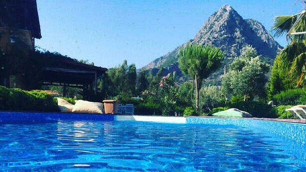 Una piscina azul cristalina con una montaña al fondo.