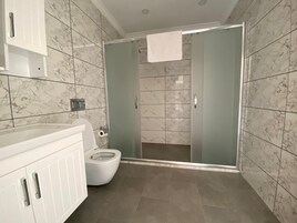 Habitación Deluxe | Baño | Ducha, artículos de higiene personal gratuitos y secador de pelo