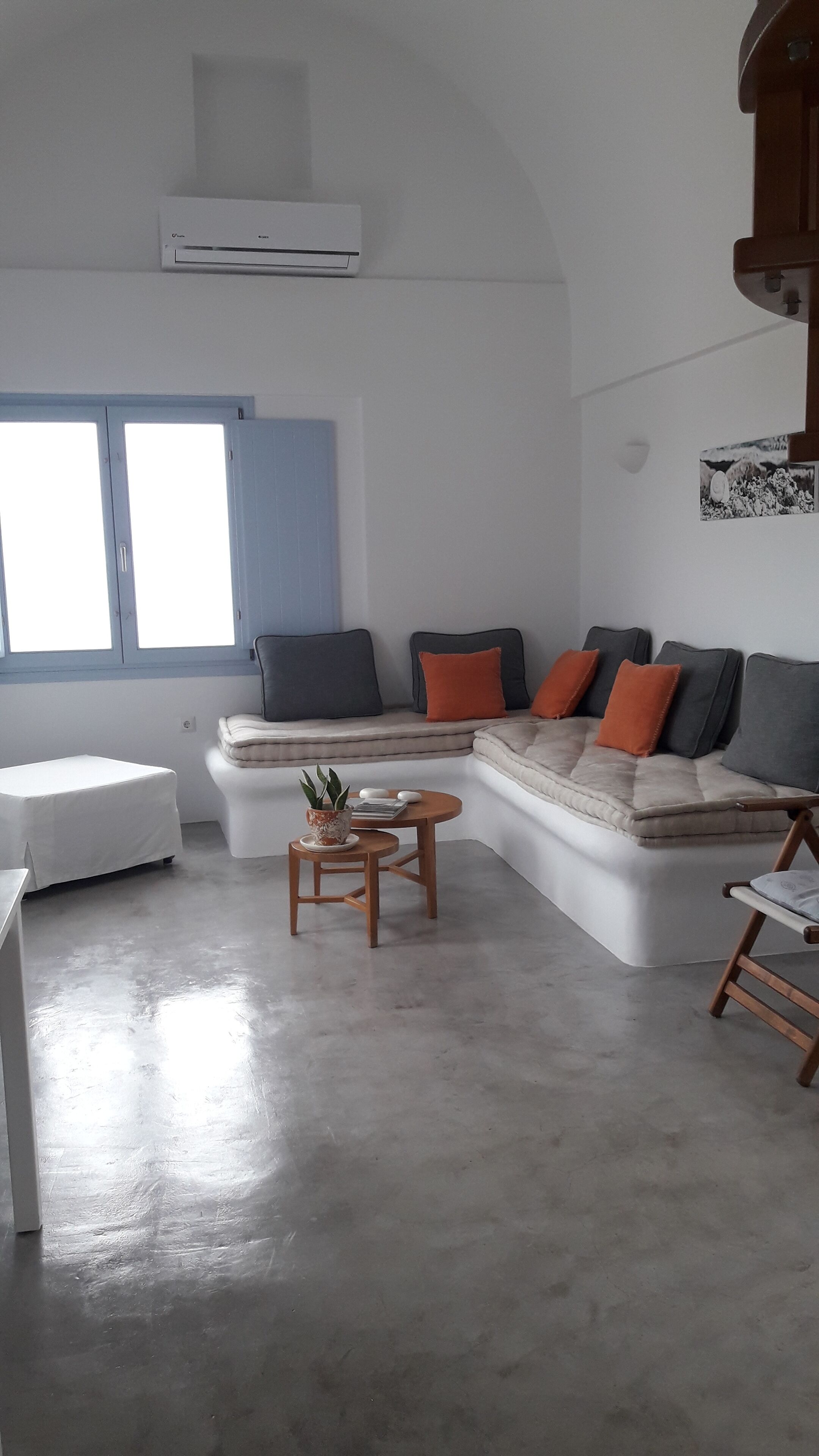 Een moderne woonkamer met een hoekbank, een klein rond tafeltje en een witte fauteuil.